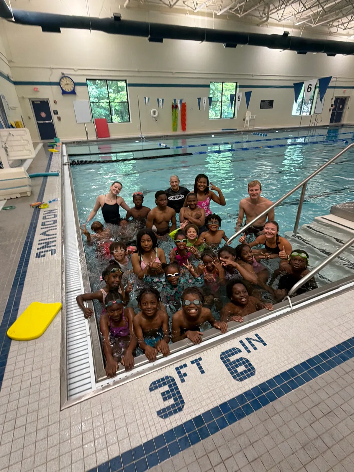 Young swimmers gathered in a pool at swim camp
